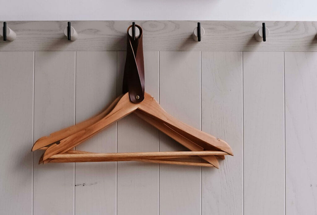 A few wooden hangers hanging on a peg