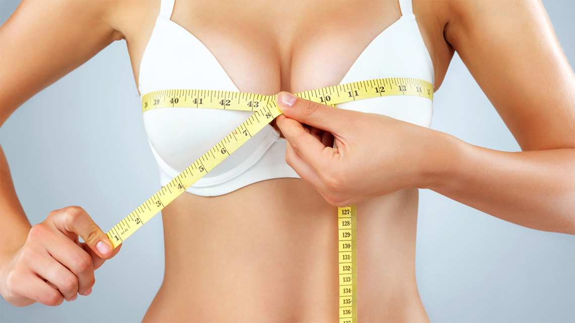 woman taking bust measurement for her body shape analysis