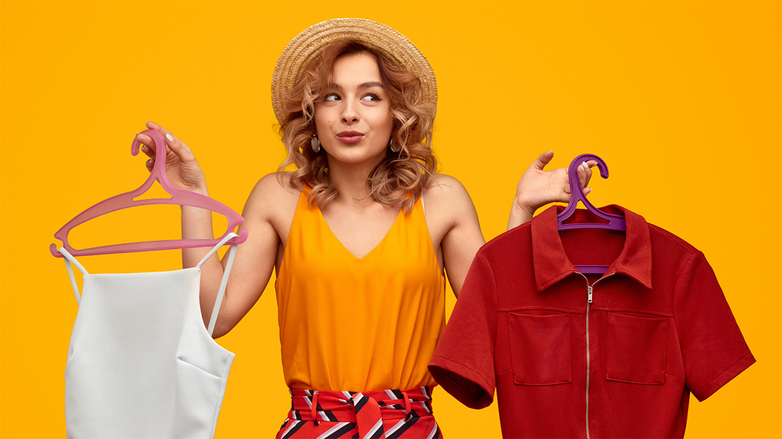 a woman choosing between two outfits on a yellow background for her body shape