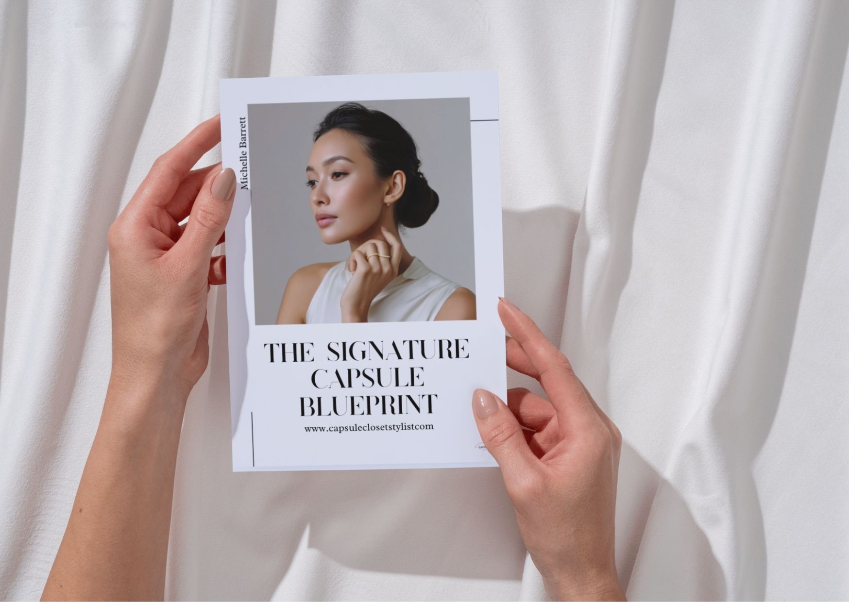 The Capsule wardrobe Bueprint held in hands on a white background